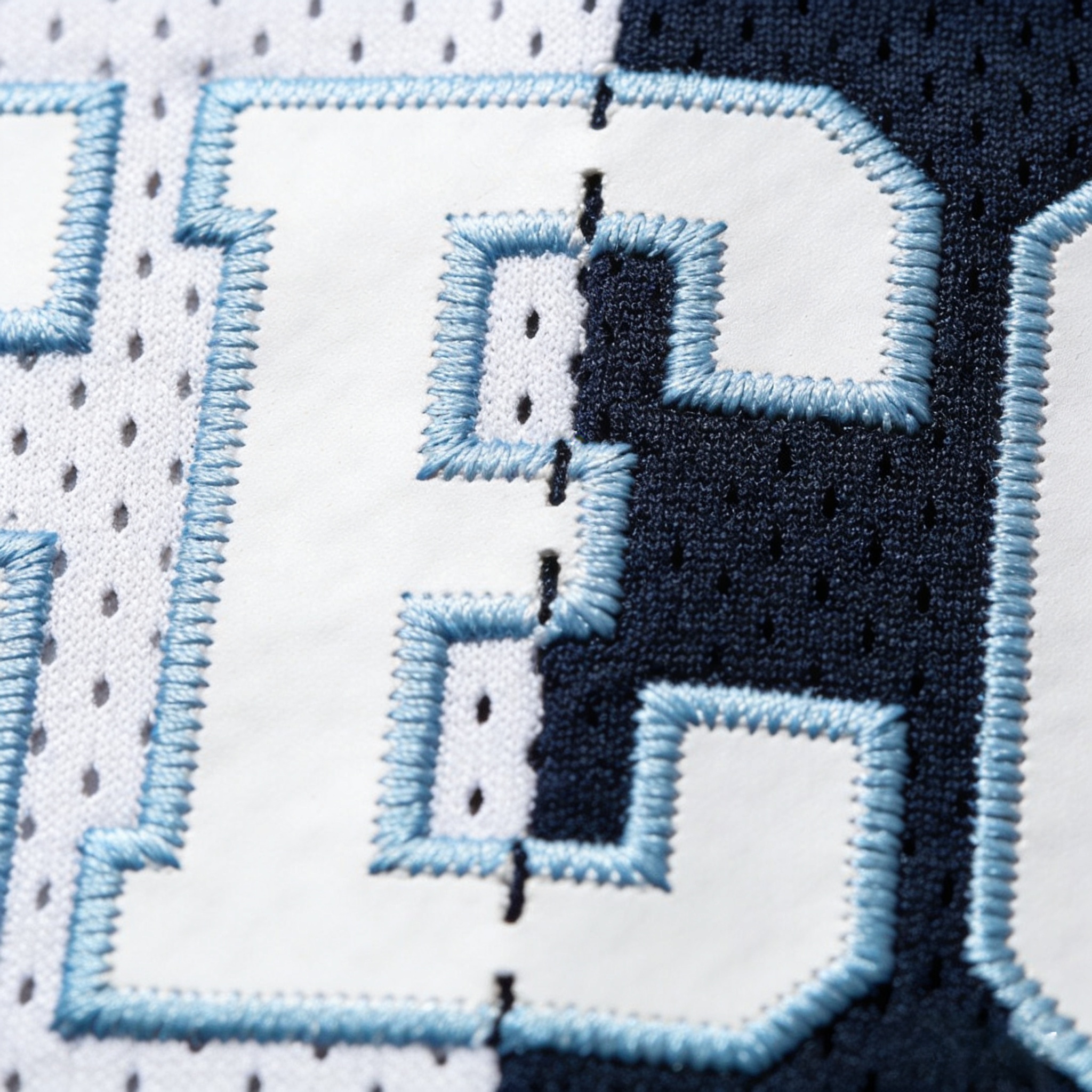 Toronto Blue Jays Jersey: Representing Canada in Blue 4 Macro close up of the light blue and white stitched split-font on a Blue Jays jersey.