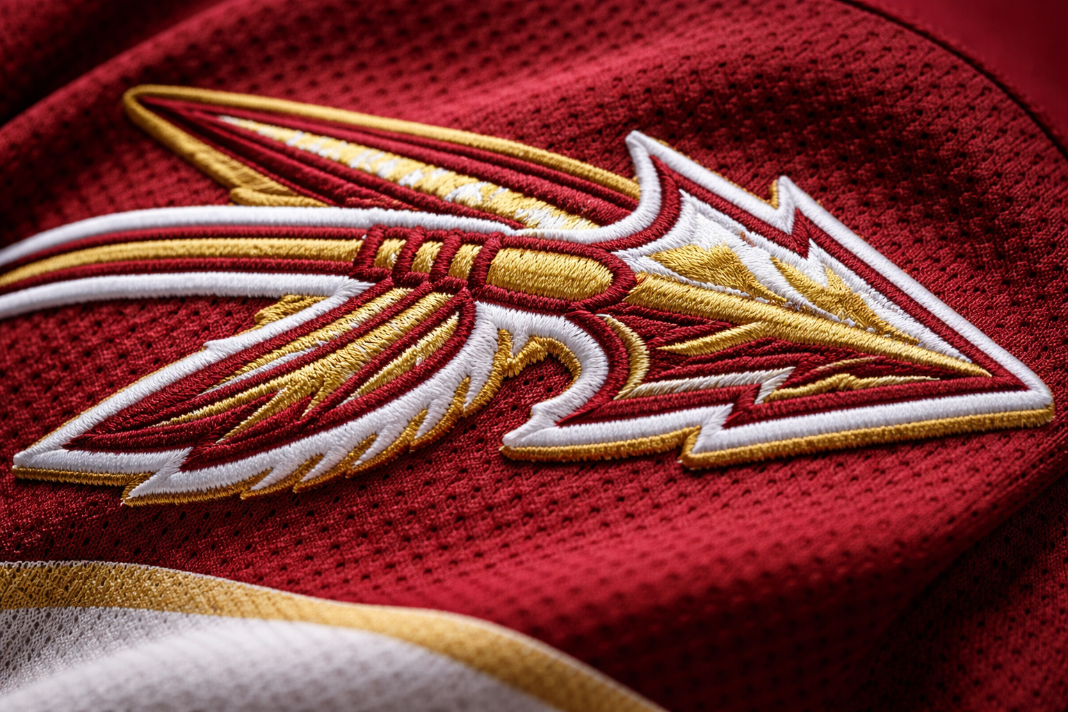  Close up of the high-quality embroidered spear logo on an FSU jersey shoulder.