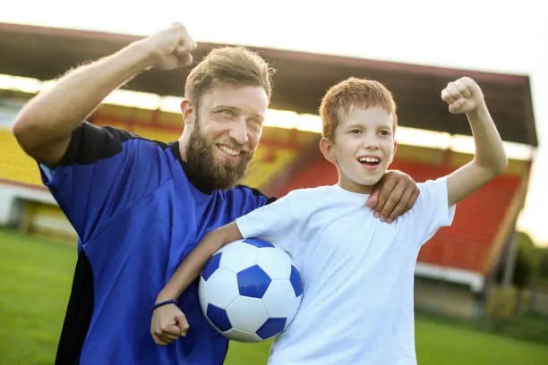 Father and son wearing affordable team jerseys from Ujersery.us