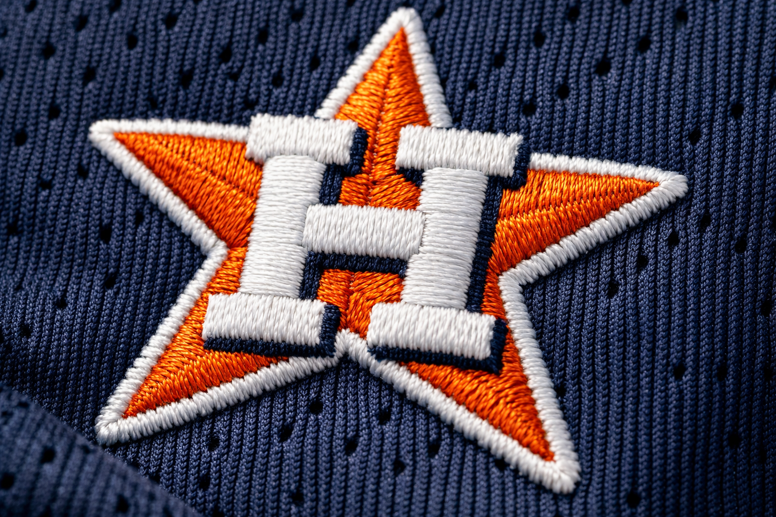 Houston Astros Jersey: From Tequila Sunrise to Modern Glory 3 Macro close up of the navy and orange stitched Star H logo on an Astros jersey.