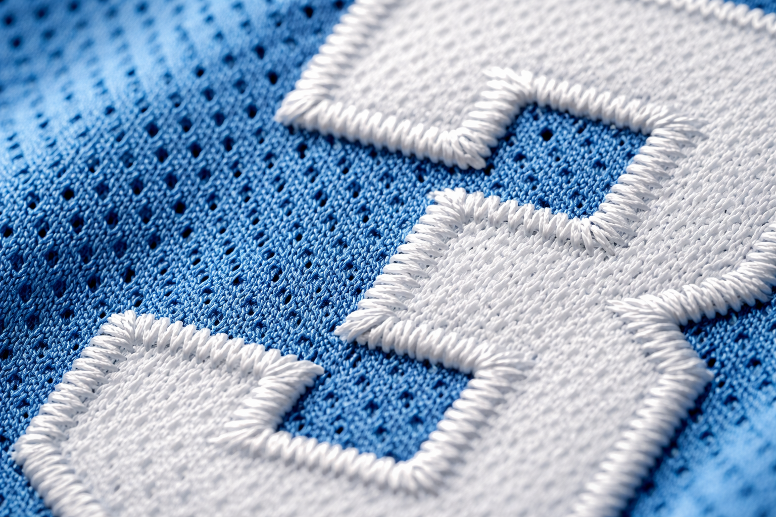 Macro close up of stitched white number 23 on a Carolina Blue basketball jersey