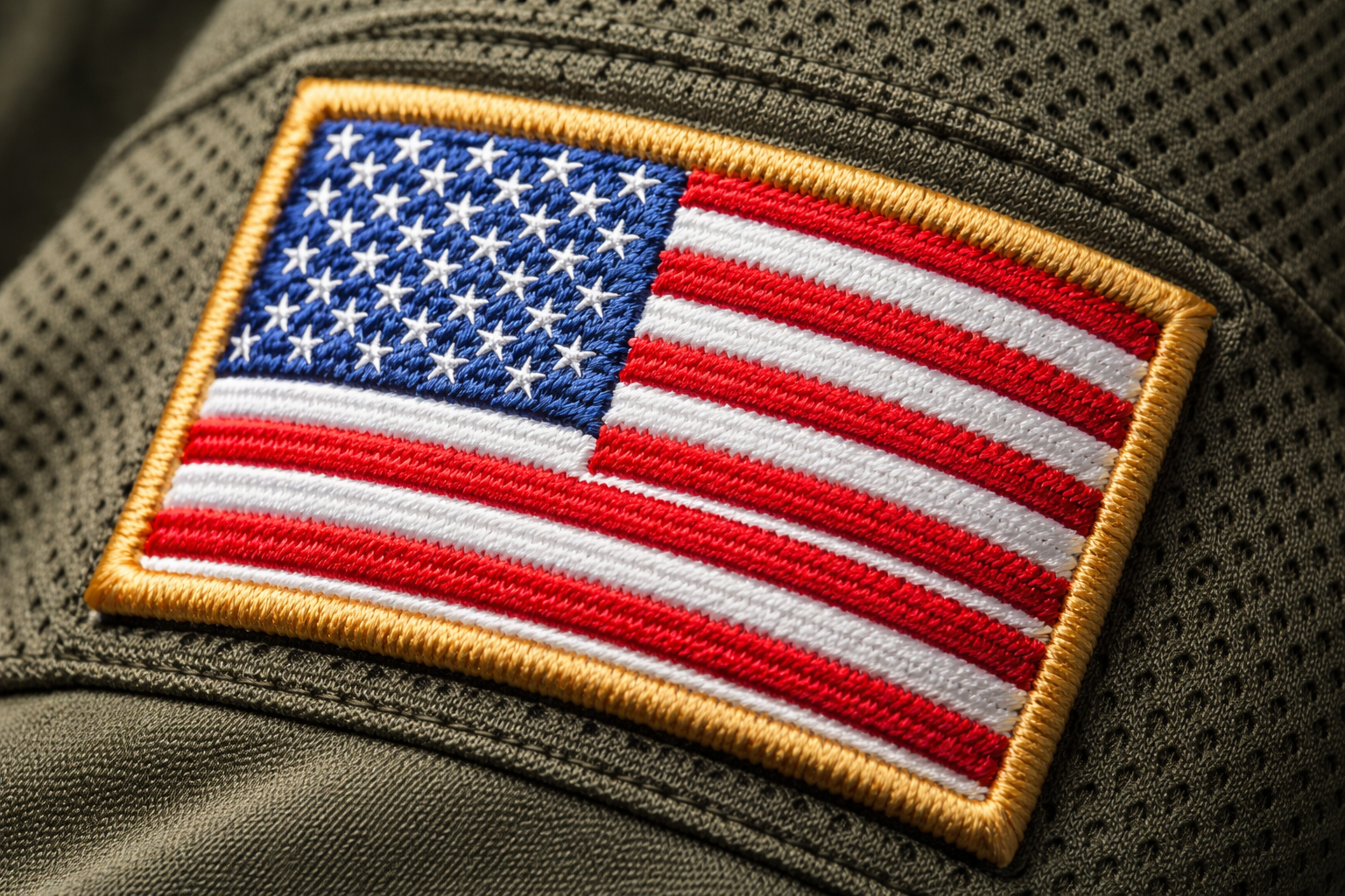 Macro close up of the embroidered American flag patch on a football jersey sleeve.