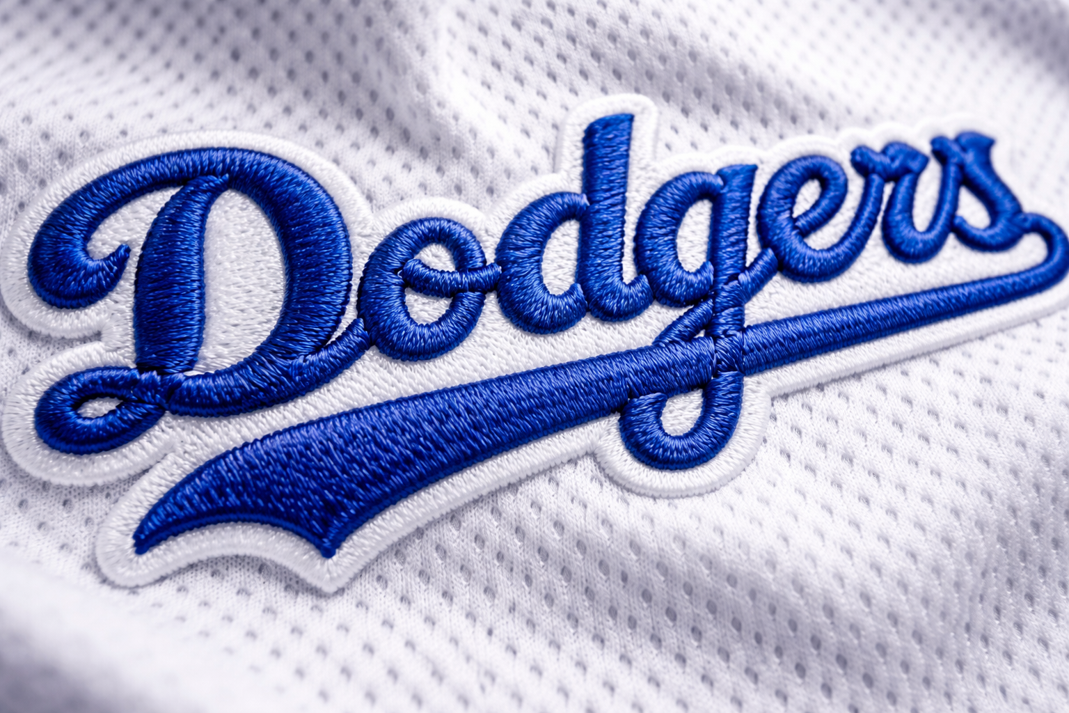 Macro close up of the blue stitched Dodgers script on a white baseball jersey