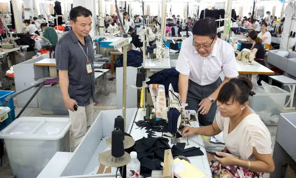 Skilled worker inspecting stitched details on a direct-from-manufacturer jersey 