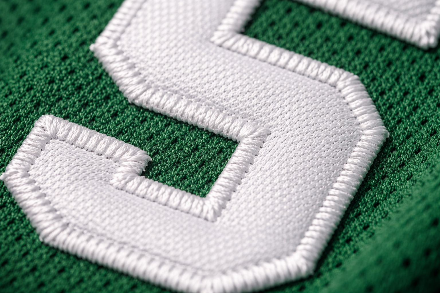 Macro close up of the white stitched lettering on a green Celtics jersey
