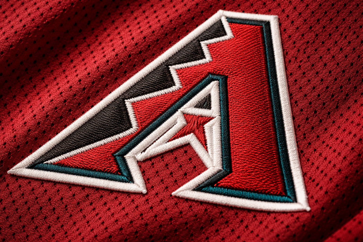 Macro close up of the stitched 'A' logo on an Arizona Diamondbacks jersey.