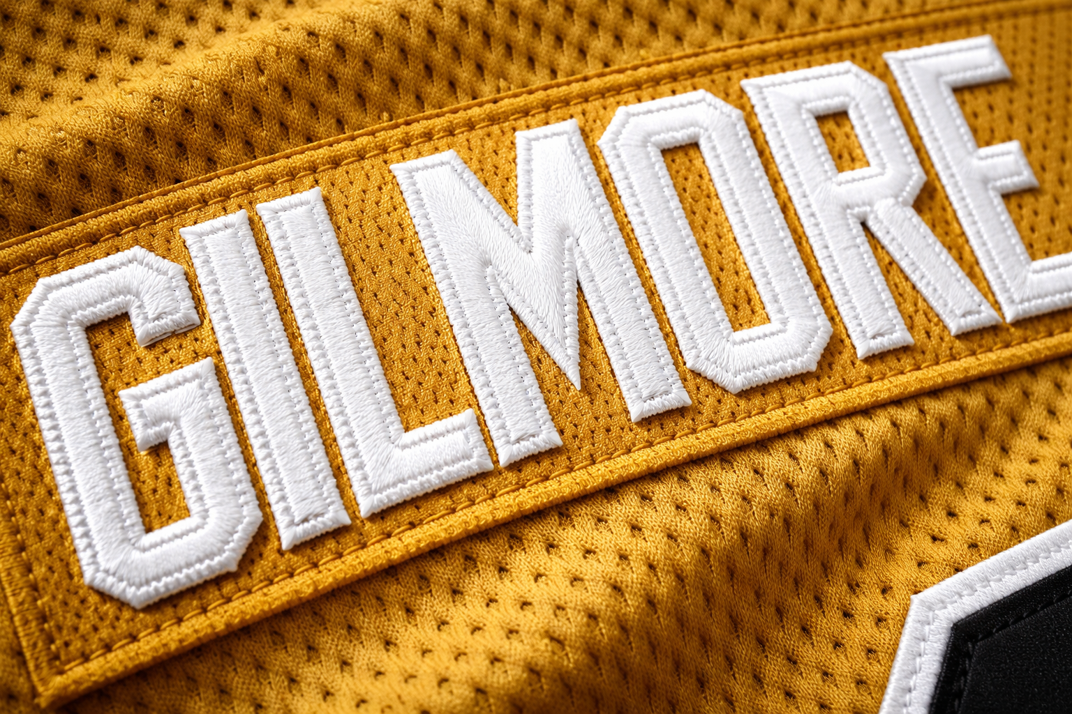 Happy Gilmore Hockey Jersey: A Tribute to Adam Sandler 3 Macro close up of the stitched 'GILMORE' nameplate on a gold hockey jersey.