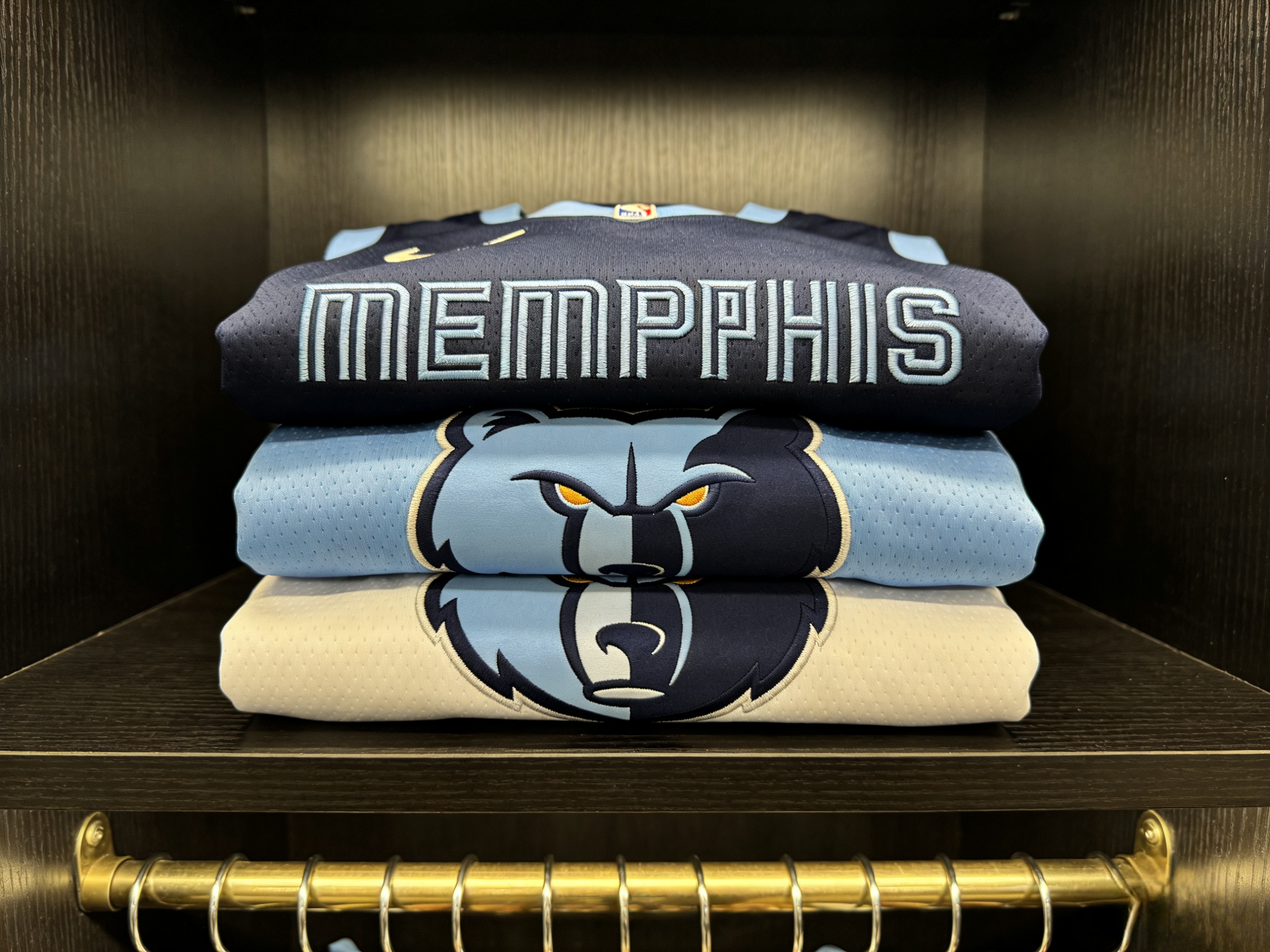  A stack of folded Memphis Grizzlies jerseys in various colors.