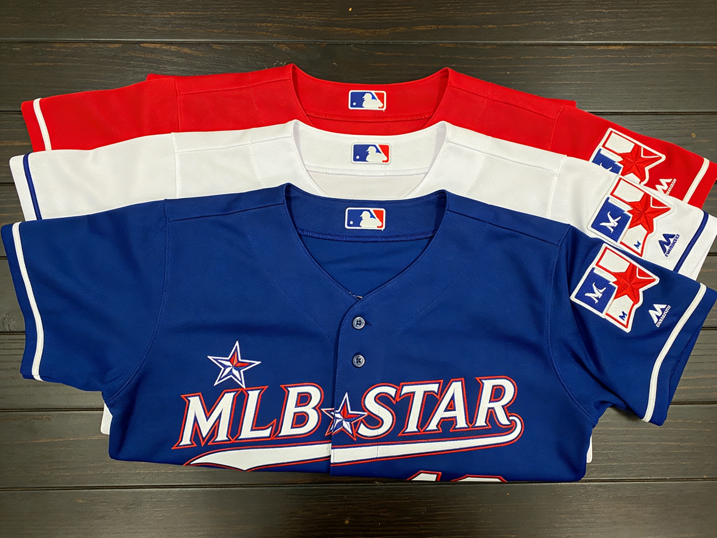 Stacks of folded MLB All-Star jerseys showing various colors and team styles.