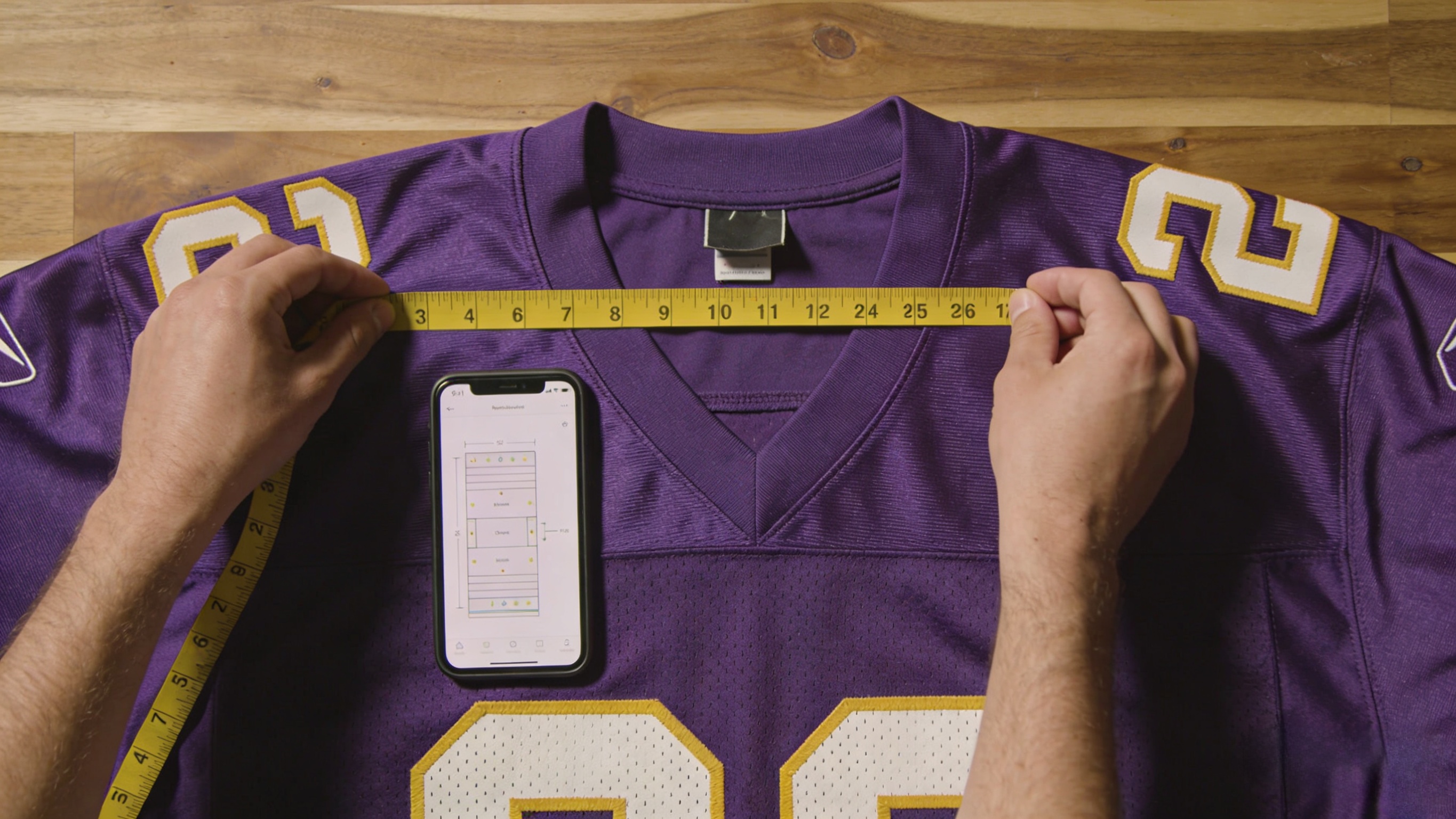 A fan measuring a football jersey to find the perfect fit using a size chart.