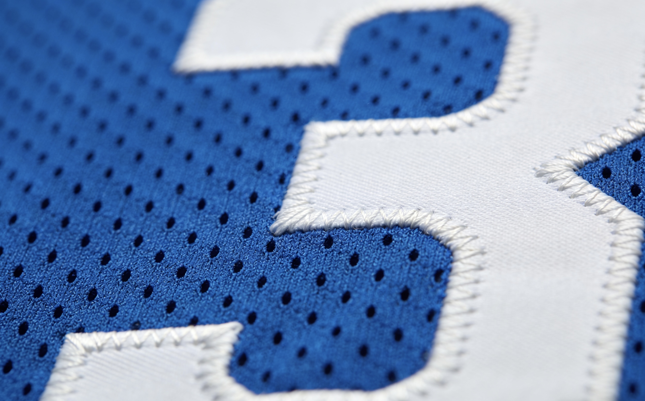 Macro close up of the high-quality stitching on a vintage 76ers NBA jersey.