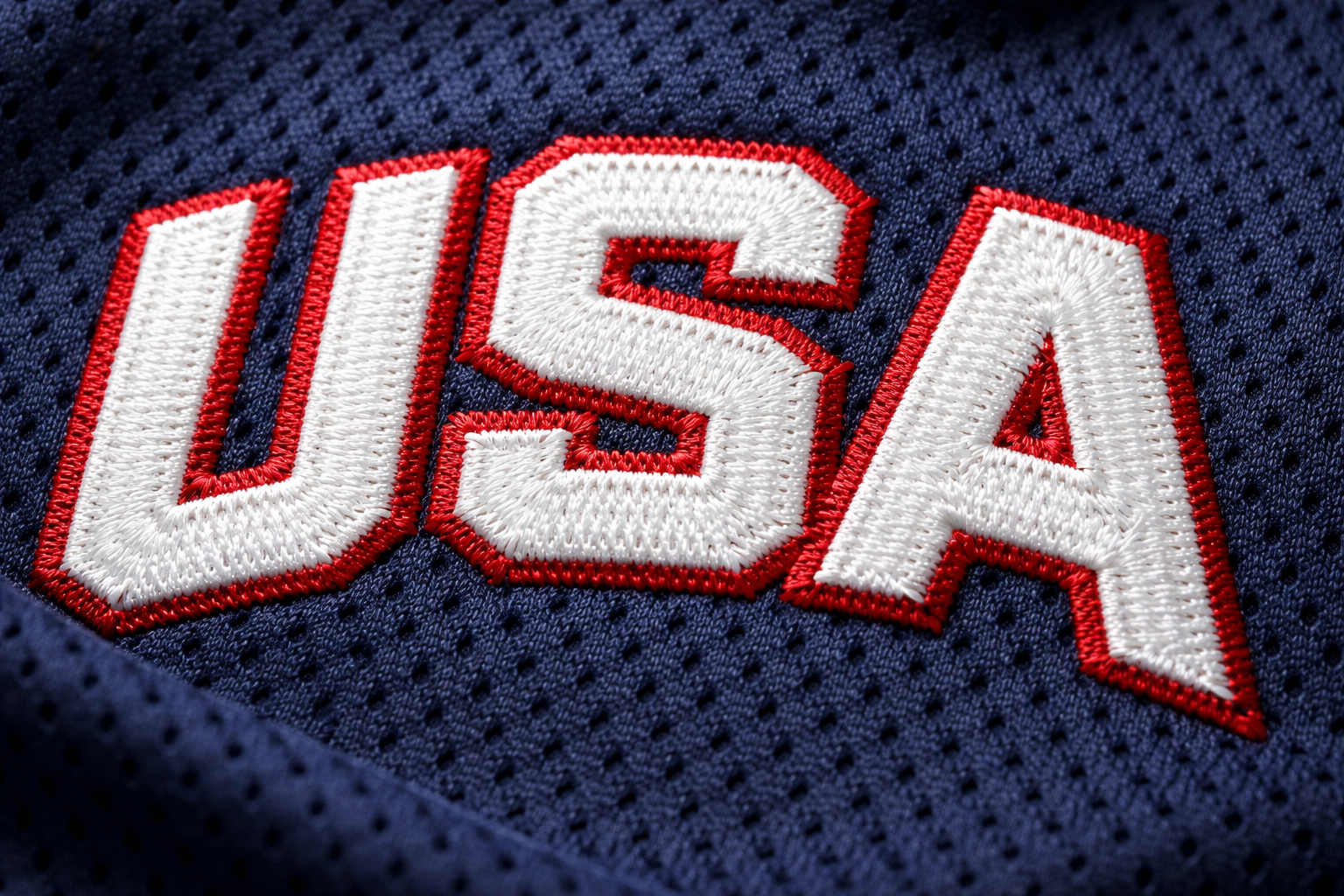 Team USA Hockey Jersey Guide: Stitched Gear for the Olympics 3 Macro close up of the white stitched USA letters on a blue hockey jersey