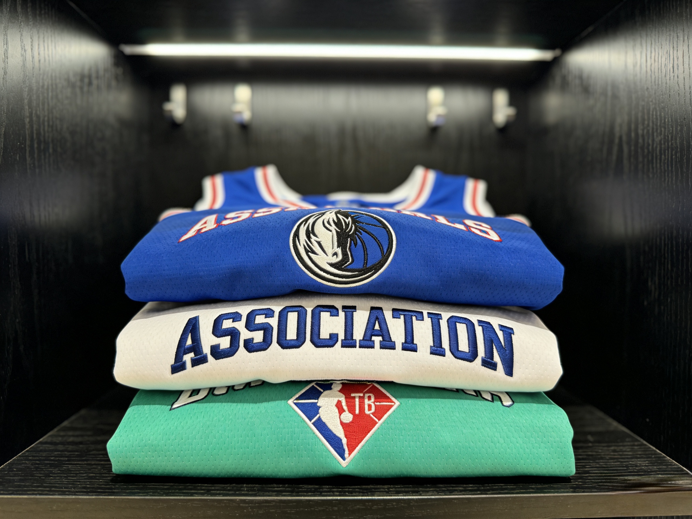 A stack of neatly folded Timberwolves jerseys in blue, white, and neon green