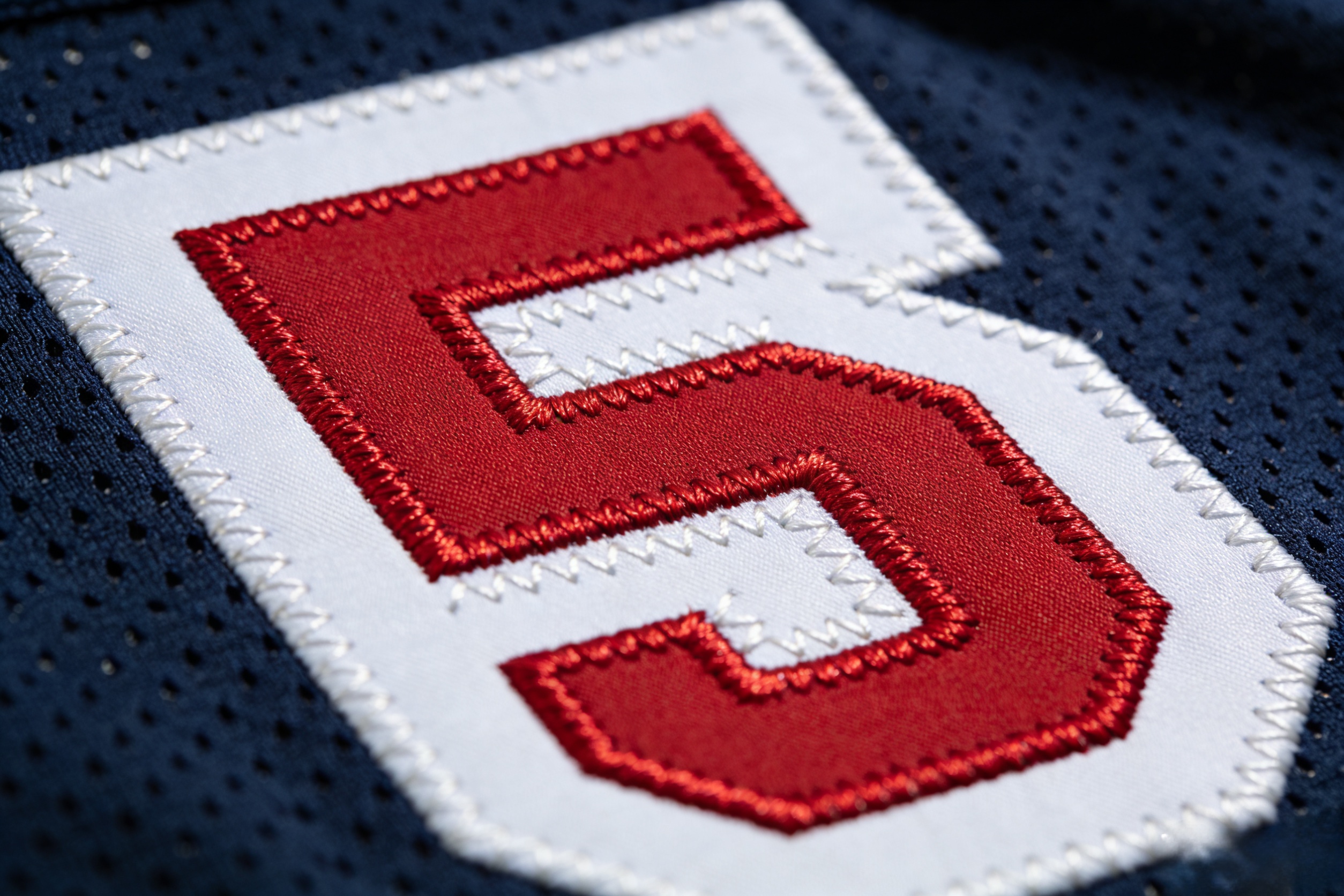 Ujersery Reviews: What Fans Really Think of Our Gear 2 Macro close up of high quality stitched tackle twill numbers on a football jersey.