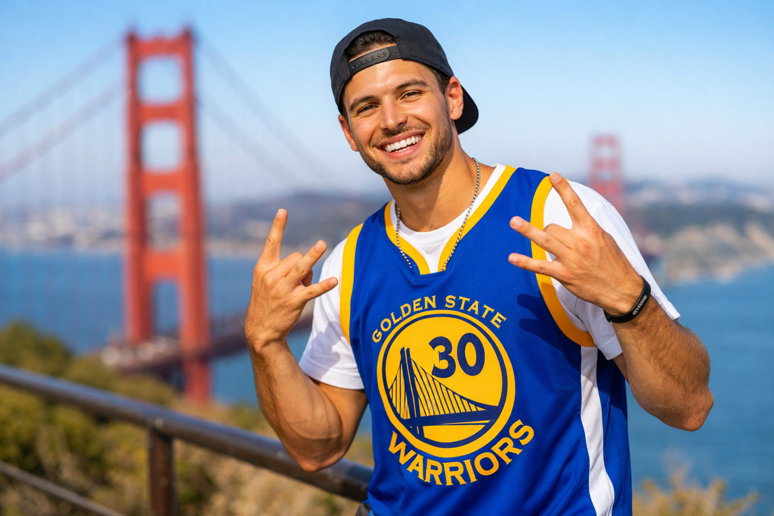 A fan wearing a Steph Curry jersey standing in front of the Golden Gate Bridge