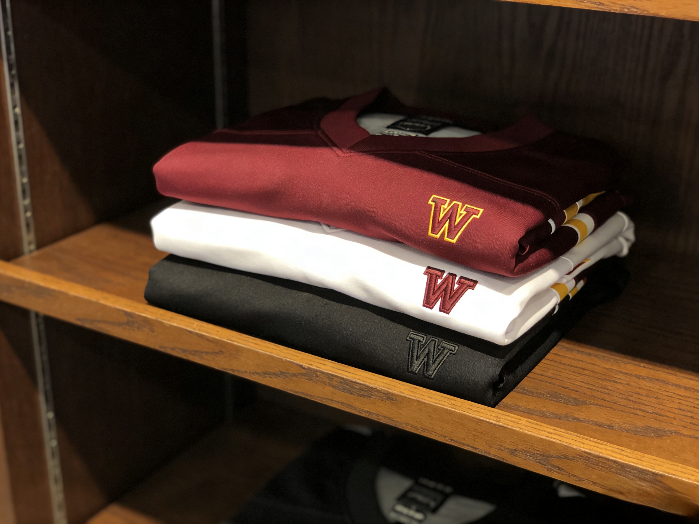 Jayden Daniels Jersey: The Guide to the New Commanders Era 5 A stack of folded Washington Commanders jerseys in various colors