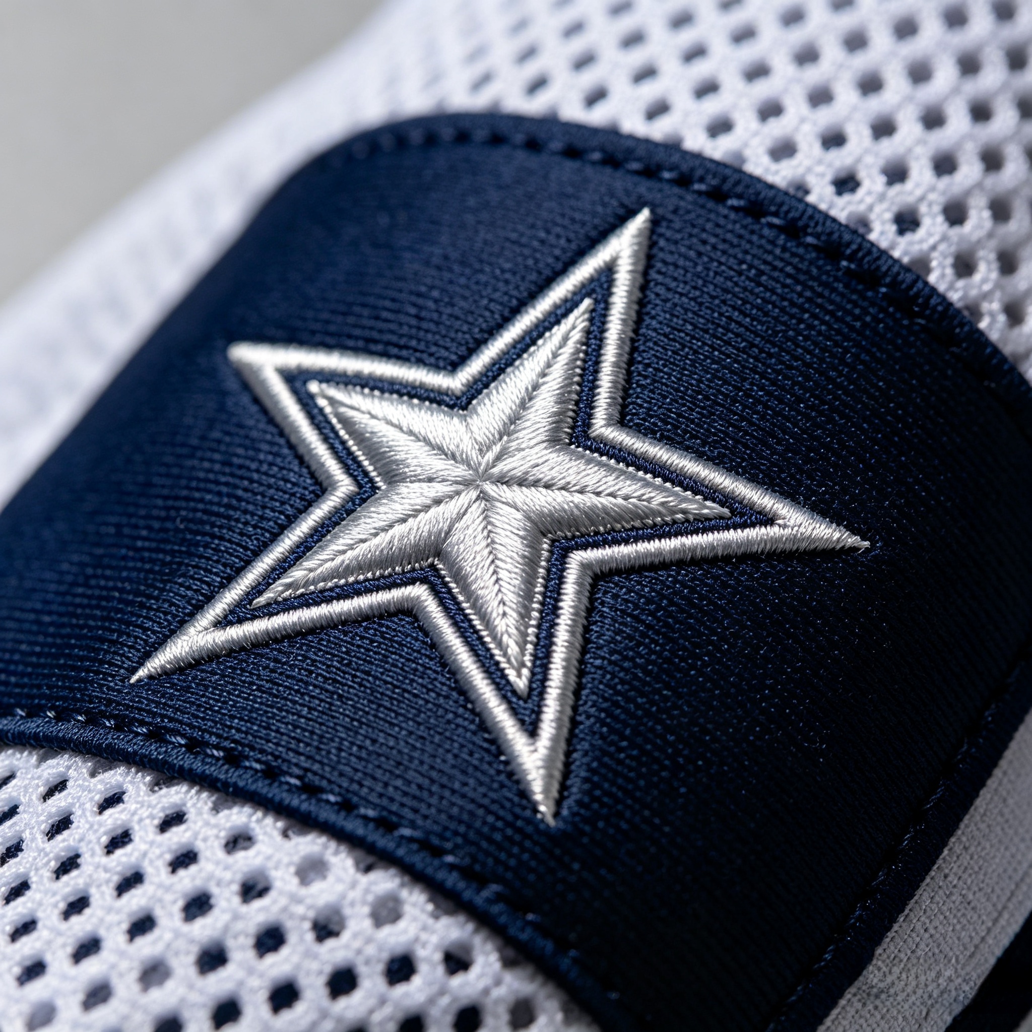 Macro close up of stitched star logo on a Dallas Cowboys jersey.